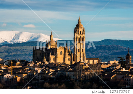 Breathtaking view of Segovia cathedral and cityscape with Guadarrama mountains. 127373797