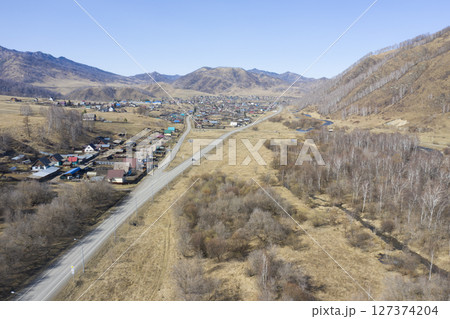 Aerial view of the village of Cherga at the mountains and the Sema River in the Altai Mountains 127374204