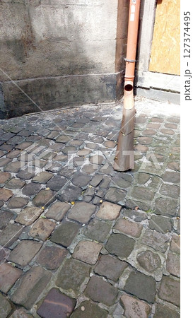 Rain Pipe Situated on Cobblestone Street in Historic Old Town Area Rain Pipe Situated on Cobblestone Street in Historic Old Town Area 127374495