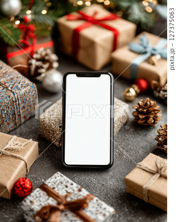 Smartphone awaits creative ideas in cozy holiday setting surrounded by gifts 127375063