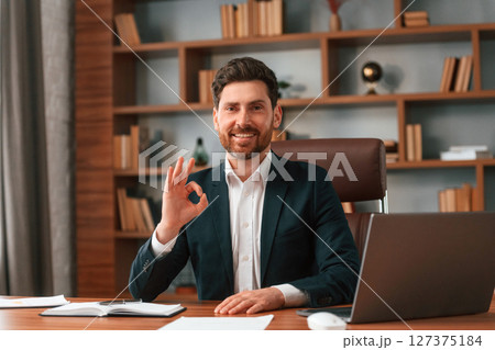 Front view. Businessman in formal clothes is working indoors Front view. Businessman in formal clothes is working indoors 127375184