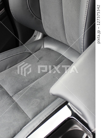 Dents and scuffs on the leather surface of a car seat trimmed with leather and alcantara 127375342