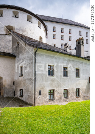 Kufstein Fortress stands proudly in Tyrol, Austria, showcasing its impressive architecture against a backdrop of green lawns and cloudy skies, inviting visitors to explore its rich history. 127375530