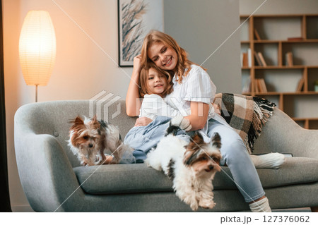Conception of parenting. Mother with her daughter and with two cute dogs is in domestic room Conception of parenting. Mother with her daughter and with two cute dogs is in domestic room 127376062