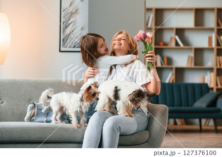 In domestic room. Mother with her daughter and with two cute dogs In domestic room. Mother with her daughter and with two cute dogs 127376100