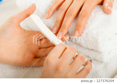 Woman getting manicure done file nails 127376204