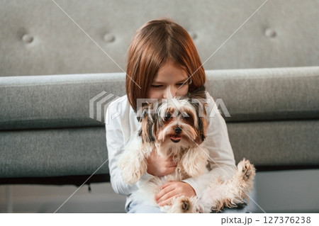 Little girl is at home with cute dog Little girl is at home with cute dog 127376238