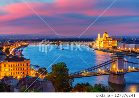 Panoramic evening view of Budapest with Parliament building, Chain Bridge and Danube river at sunset Panoramic evening view of Budapest with Parliament building, Chain Bridge and Danube river at sunset 127376241