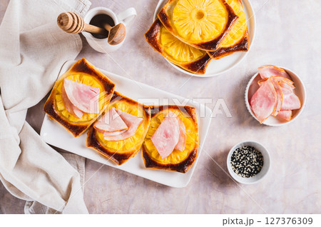 Crispy tarts with pineapple and prosciutto on a plate on the table top view 127376309