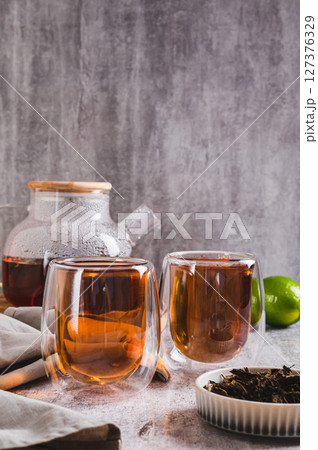 Earl Grey tea with bergamot in cups and teapot on table vertical view 127376329