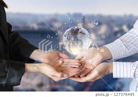Hands holding a globe with green energy. 127376495