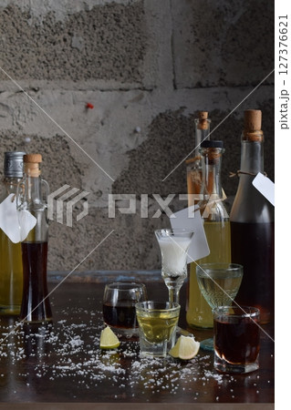 Assorted alcohol shot glasses arranged on reflective table surface in daylight. Concept of celebration, party, tasting variety of spirits, bar culture, social drinking, diversity of colorful alcoholic Assorted alcohol shot glasses arranged on reflective table surface in daylight. Concept of celebration, party, tasting variety of spirits, bar culture, social drinking, diversity of colorful alcoholic 127376621