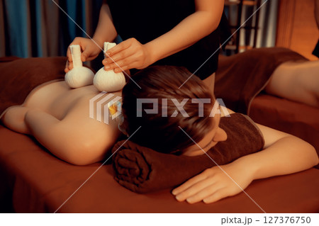 Hot herbal ball spa massage body treatment with couple customer. Quiescent Hot herbal ball spa massage body treatment with couple customer. Quiescent 127376750