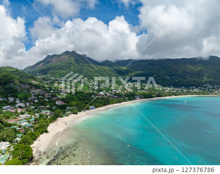 Curved sandy beach with mountainous surroundings, crystal clear waters and gentle waves. Seychelles, Mahe. Beau Vallon Beach. Curved sandy beach with mountainous surroundings, crystal clear waters and gentle waves. Seychelles, Mahe. Beau Vallon Beach. 127376786