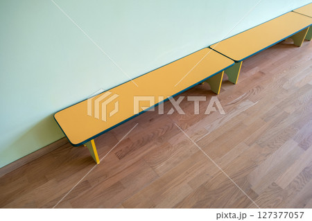 Yellow benches inside a school sports gym. Yellow benches inside a school sports gym. 127377057