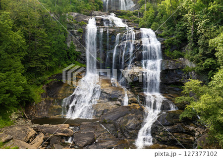 Whitewater Falls with falling down clear water from rocky boulders between green lush woods in Nantahala National Forest, North Carolina, USA 127377102