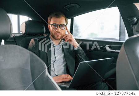 In comfortable modern automobile. Man in formal business clothes In comfortable modern automobile. Man in formal business clothes 127377548