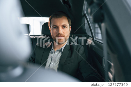 In comfortable modern automobile. Man in formal business clothes In comfortable modern automobile. Man in formal business clothes 127377549