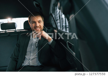 In comfortable modern automobile. Man in formal business clothes 127377550