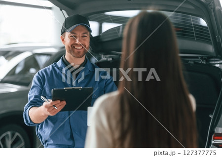 Young woman is visiting auto mechanic in garage. Repair service Young woman is visiting auto mechanic in garage. Repair service 127377775