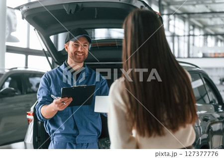 Young woman is visiting auto mechanic in garage. Repair service Young woman is visiting auto mechanic in garage. Repair service 127377776
