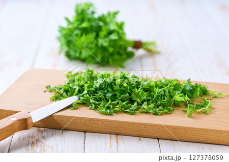 Fresh chopped parsley on a cutting board, selective focus. 127378059