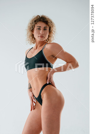Standing and posing. Young caucasian woman with athletic body shape is indoors at daytime 127378094