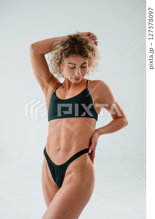 Beautiful abs. Young caucasian woman with athletic body shape is indoors at daytime Beautiful abs. Young caucasian woman with athletic body shape is indoors at daytime 127378097