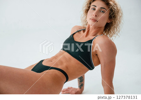 On the hands and legs. On the floor. Young caucasian woman with athletic body shape is indoors at daytime 127378131