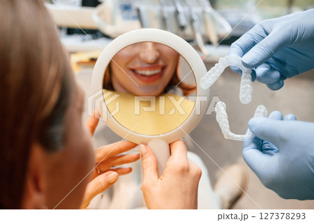 Woman in the stomatology clinic, visiting dentist, installing the aligner Woman in the stomatology clinic, visiting dentist, installing the aligner 127378293