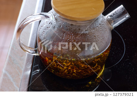 tea is brewed in a glass teapot, evaporation drops on the walls of the teapot tea is brewed in a glass teapot, evaporation drops on the walls of the teapot 127379321