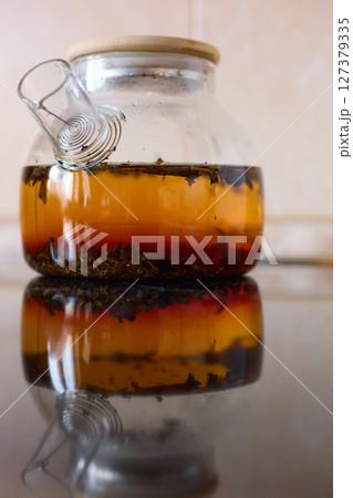 tea is brewed in a glass teapot, evaporation drops on the walls of the teapot 127379335