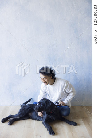 愛犬とくつろぐ男性　 127380083