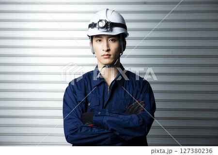 腕組みする作業着の男性  127380236