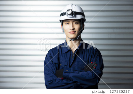 腕組みする作業着の男性  127380237