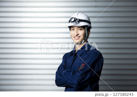 腕組みする作業着の男性  127380243