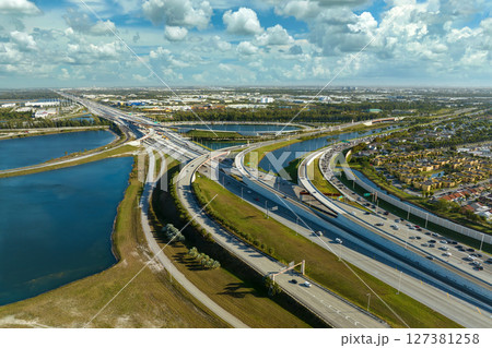 USA transportation infrastructure concept. Above view of wide highway crossroads in Miami, Florida with fast driving cars USA transportation infrastructure concept. Above view of wide highway crossroads in Miami, Florida with fast driving cars 127381258