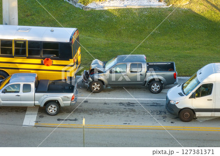 School bus and pick-up truck car crash with first responders helping at accident site on American street. Vehicle collision on road in USA School bus and pick-up truck car crash with first responders helping at accident site on American street. Vehicle collision on road in USA 127381371