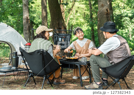 公園・キャンプ場でデイキャンプ・キャンプ・バーベキューを楽しむ仲良しのファミリー 127382343
