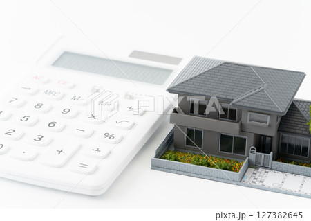 電卓とミニチュアの一戸建て住宅 電卓とミニチュアの一戸建て住宅 127382645