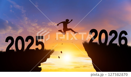 Welcome merry Christmas and Happy new year in 2026. Man jumping across the gap from 2025 to 2026 cliff with Sunset and Twilight Sky background. Welcome merry Christmas and Happy new year in 2026. Man jumping across the gap from 2025 to 2026 cliff with Sunset and Twilight Sky background. 127382870