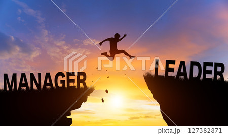 Silhouette man jumping from MANAGER to LEADER wording on cliffs with cloud sky and sunrise. Go ahead and Keep go on to success Concept. Silhouette man jumping from MANAGER to LEADER wording on cliffs with cloud sky and sunrise. Go ahead and Keep go on to success Concept. 127382871