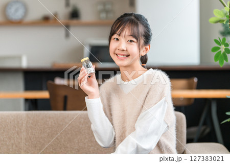 薬・サプリメントの瓶を持つ小学生,中学生,高校生の女の子 薬・サプリメントの瓶を持つ小学生,中学生,高校生の女の子 127383021