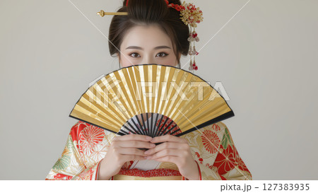 金色の扇子を持つ伝統的な着物姿の女性 127383935