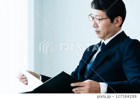 資料をチェックするビジネスマン 資料をチェックするビジネスマン 127384289