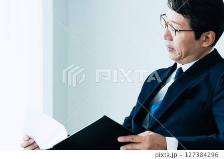 資料をチェックするビジネスマン 127384296