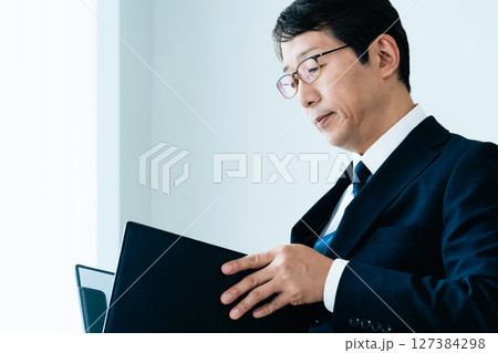 資料をチェックするビジネスマン 127384298