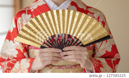 金色の扇子を持つ伝統的な着物の女性 127385225