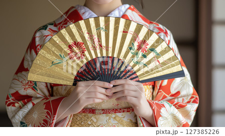 金色の扇子を持つ伝統的な着物の女性 127385226