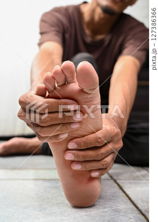 Portrait of a man with pain in his foot isolated over a white background. Concept of healthcare 127386366